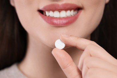 Photo of Closeup view of woman taking one pill