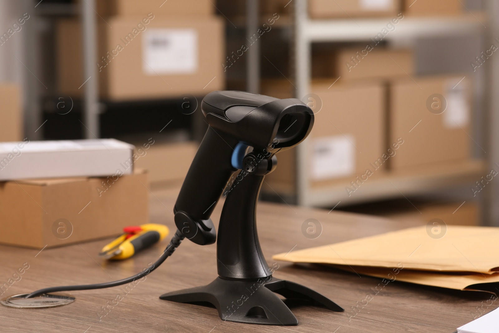 Photo of Black modern barcode scanner on wooden table in office. Online store