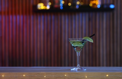 Photo of Delicious lime martini on table in bar, space for text