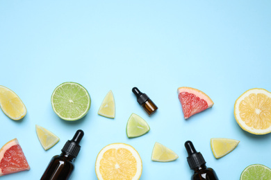 Photo of Flat lay composition with bottles of citrus essential oil on light blue background. Space for text
