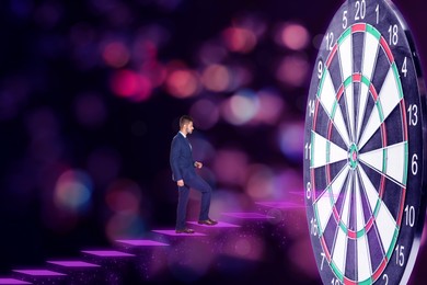 Image of Businessman stepping up on stairs to empty dart board against blurred background