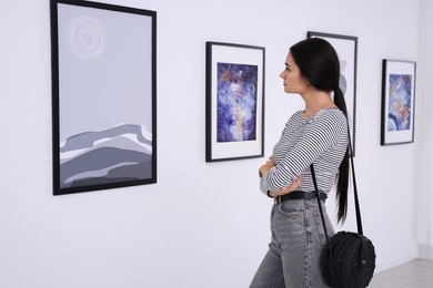 Photo of Thoughtful young woman at exhibition in art gallery