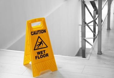 Safety sign with phrase Caution wet floor near stairs. Cleaning service