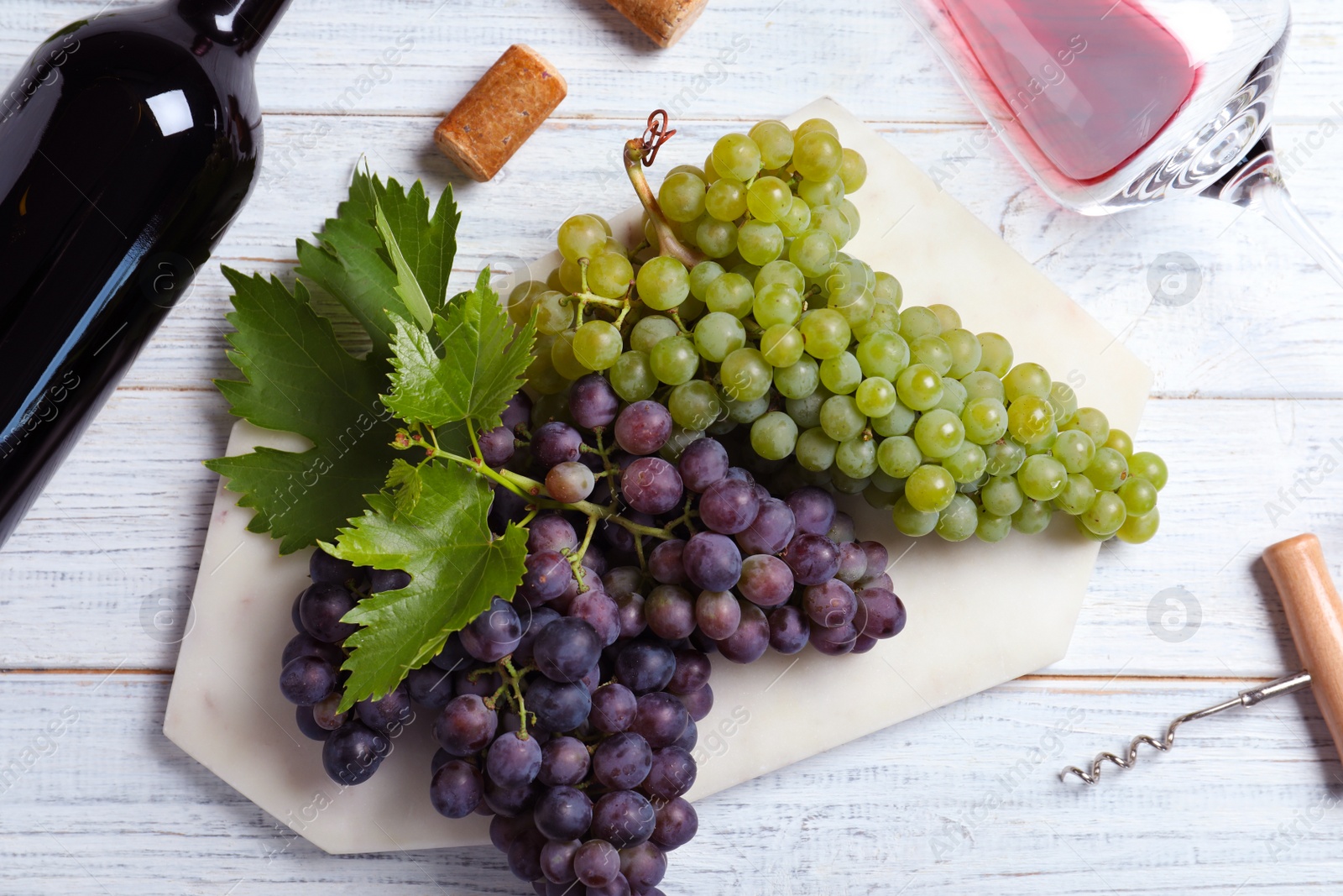 Photo of Flat lay composition with fresh ripe juicy grapes and wine on white wooden table