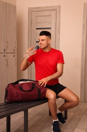 Photo of Handsome man drinking water in locker room