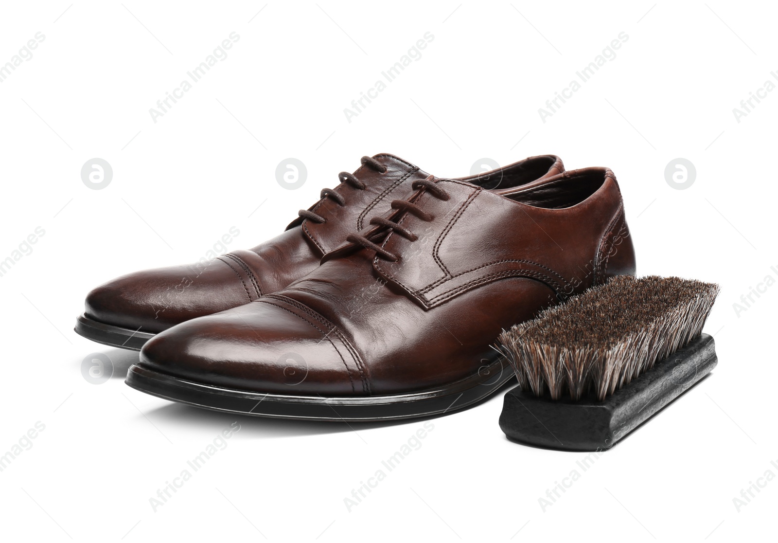 Photo of Stylish men's shoes and cleaning brush on white background