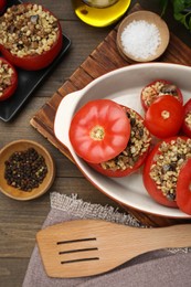 Photo of Delicious stuffed tomatoes with minced beef, bulgur and mushrooms on wooden table, flat lay