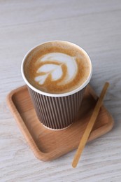Coffee to go. Paper cup with tasty drink on white wooden table
