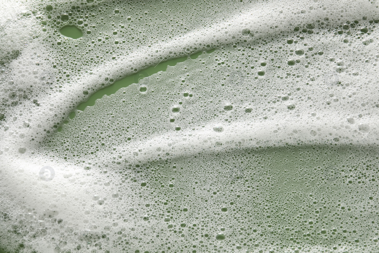 Photo of White washing foam on olive background, top view