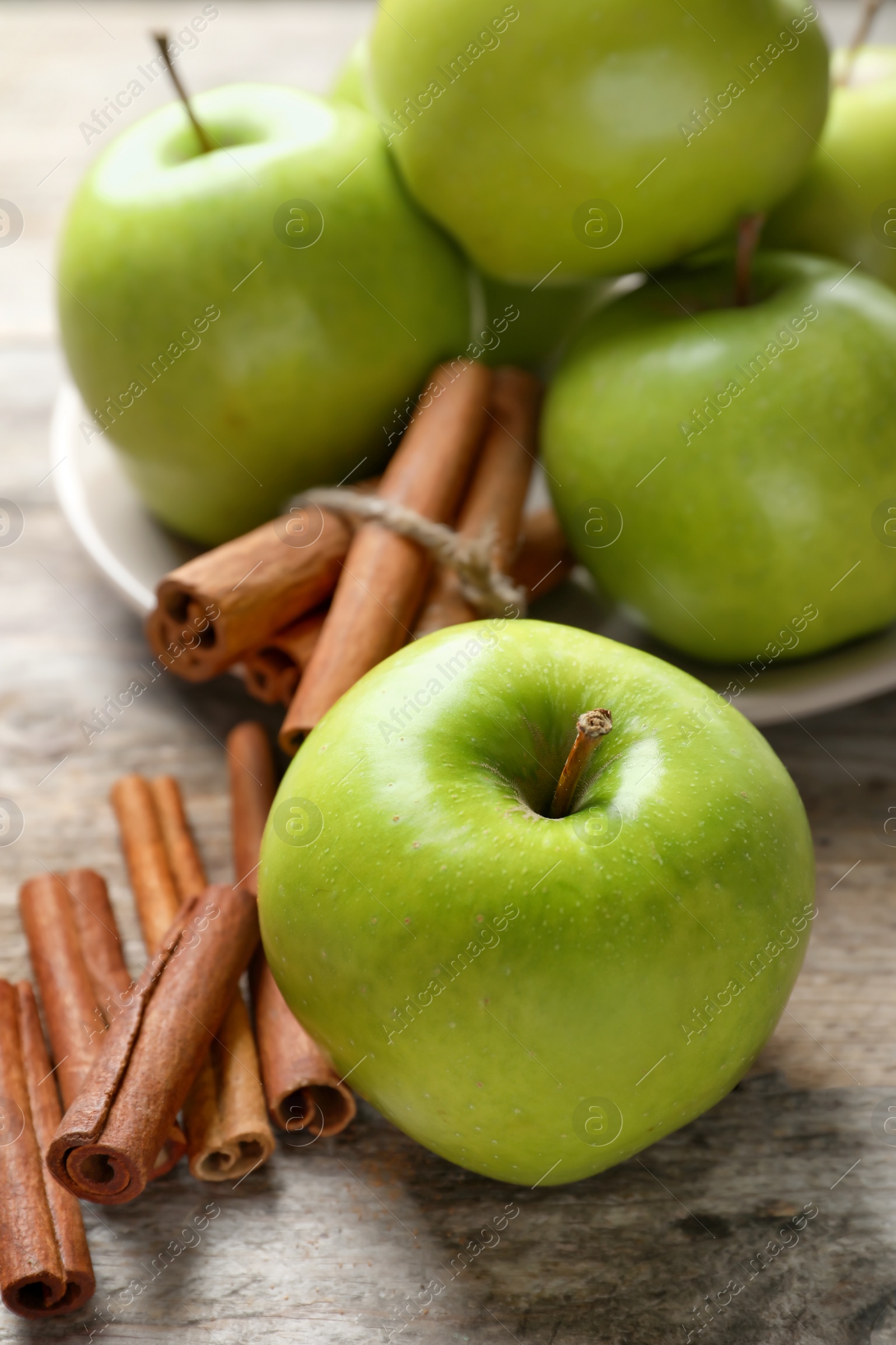 Photo of Fresh apples and cinnamon sticks on wooden table