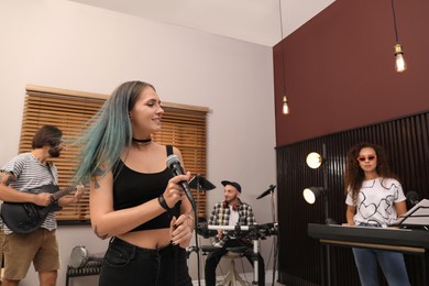 Photo of Music band performing in modern recording studio