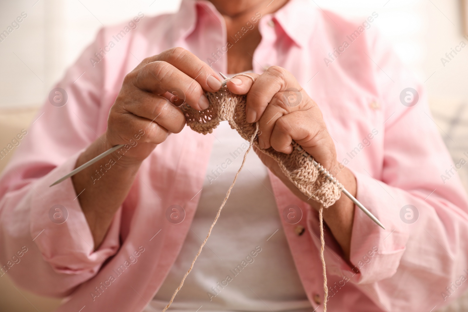 Photo of Elderly woman knitting at home, closeup. Creative hobby