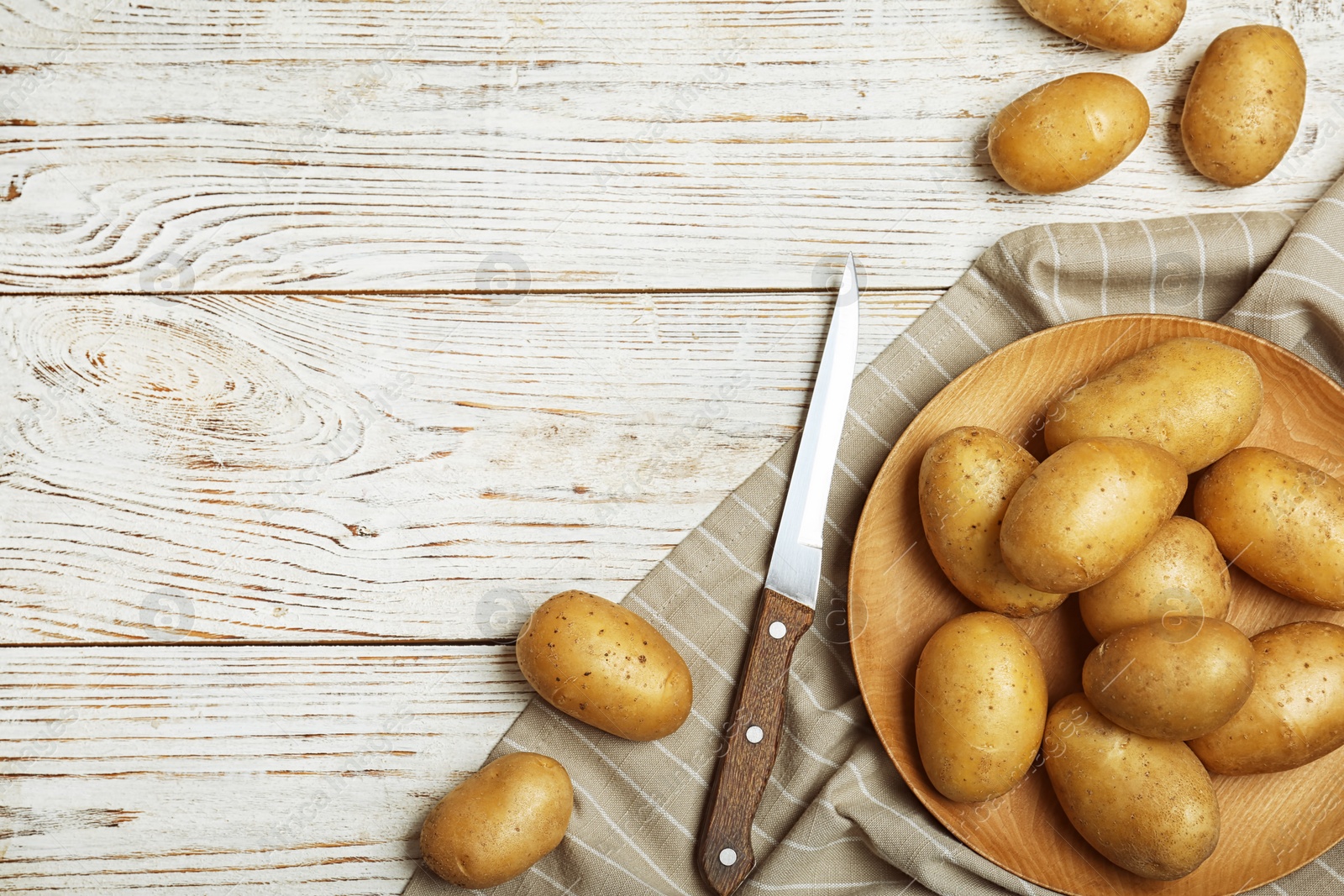 Photo of Fresh ripe organic potatoes on wooden background, top view