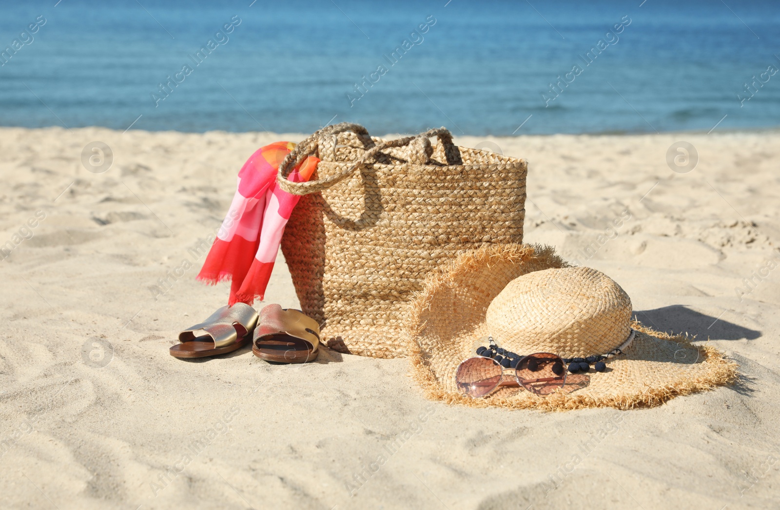 Photo of Stylish beach accessories on sandy sea shore