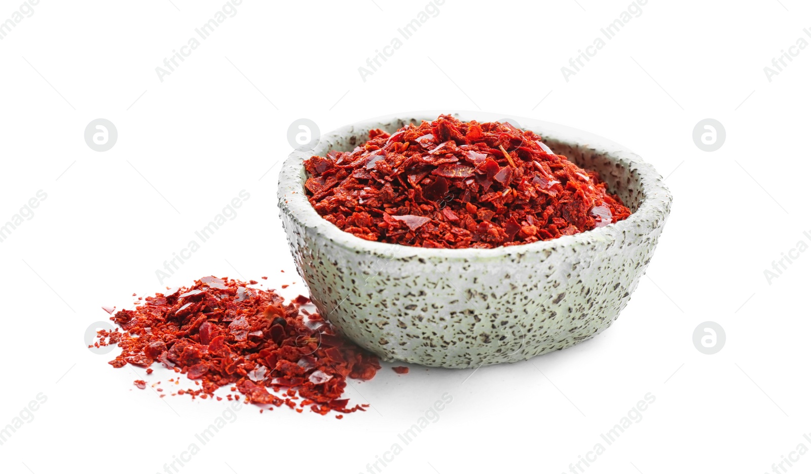 Photo of Bowl with chili pepper flakes on white background