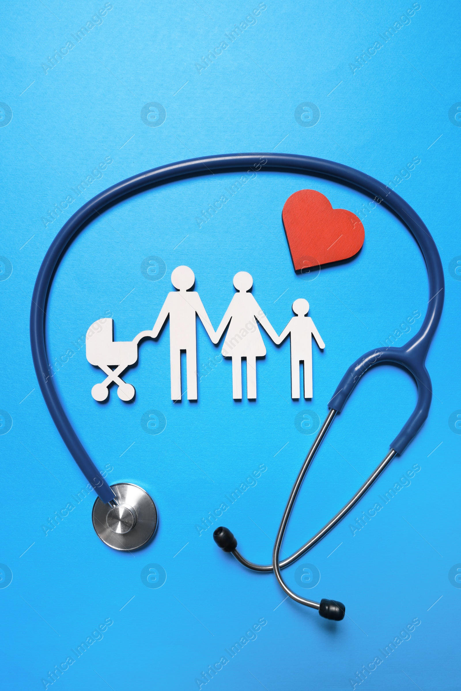 Photo of Figures of family near stethoscope on light blue background, flat lay. Insurance concept