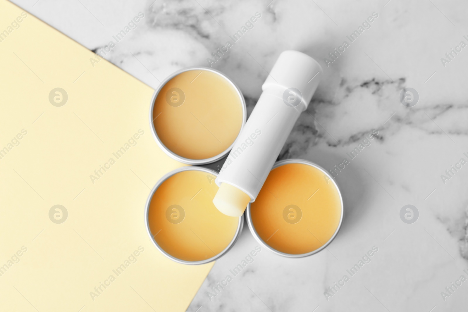 Photo of Flat lay composition with hygienic lipstick and balms on light background