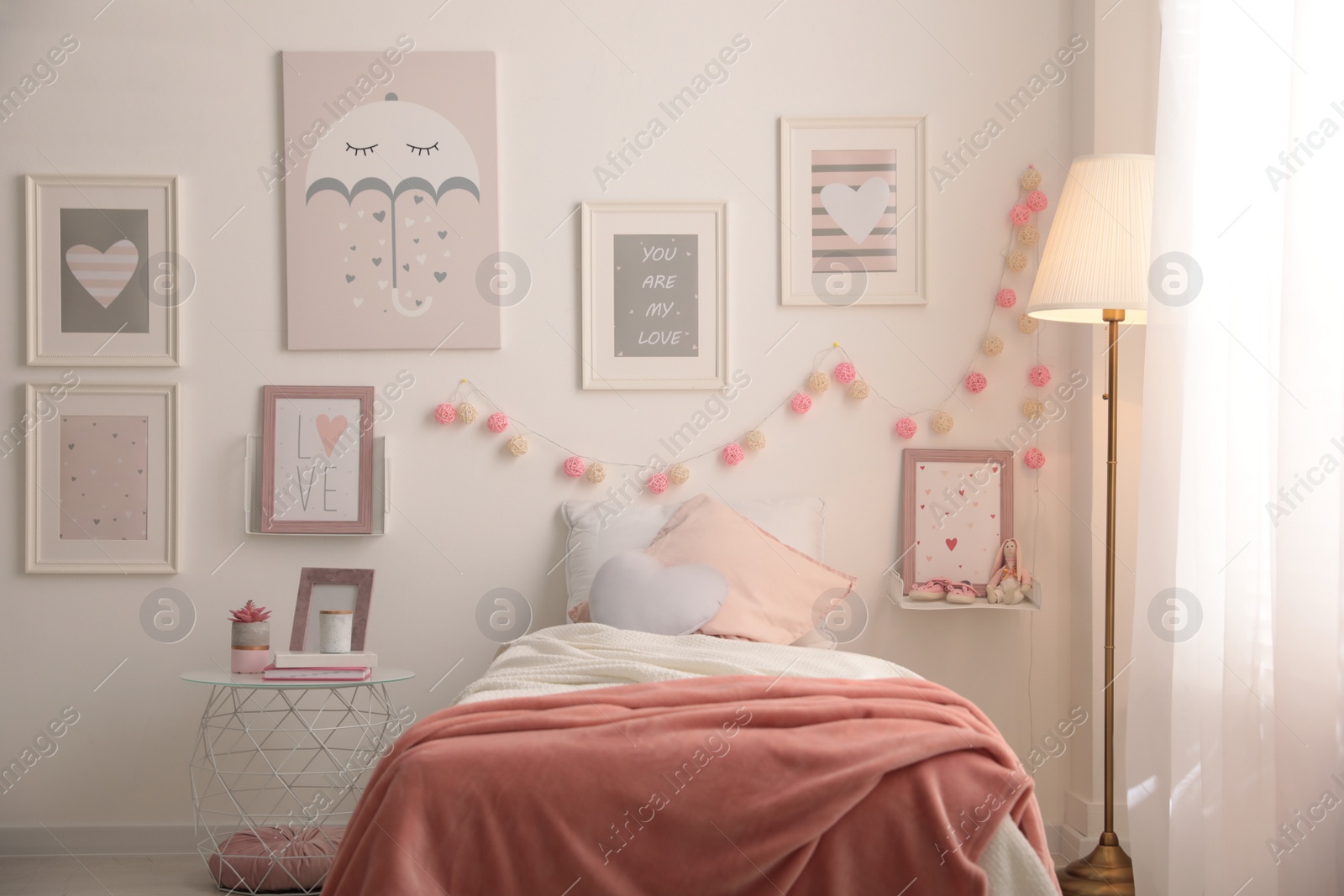 Photo of Stylish child's room interior with beautiful pictures and comfortable bed