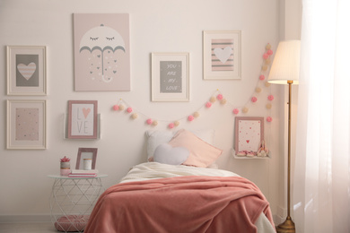 Stylish child's room interior with beautiful pictures and comfortable bed