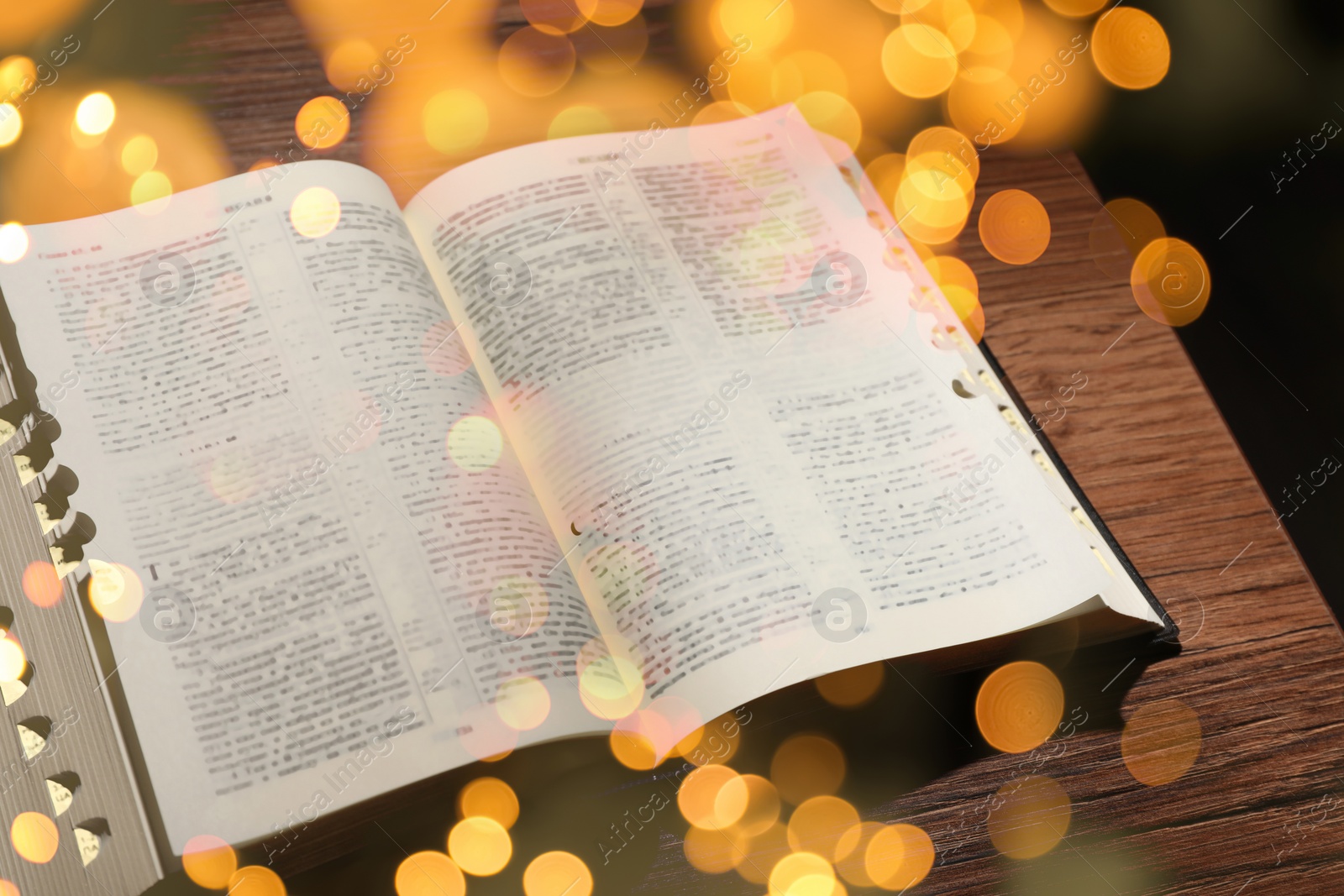 Image of Open Bible on wooden table, bokeh effect