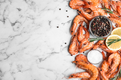 Photo of Delicious cooked shrimps with lemon and spices on white marble table, flat lay. Space for text