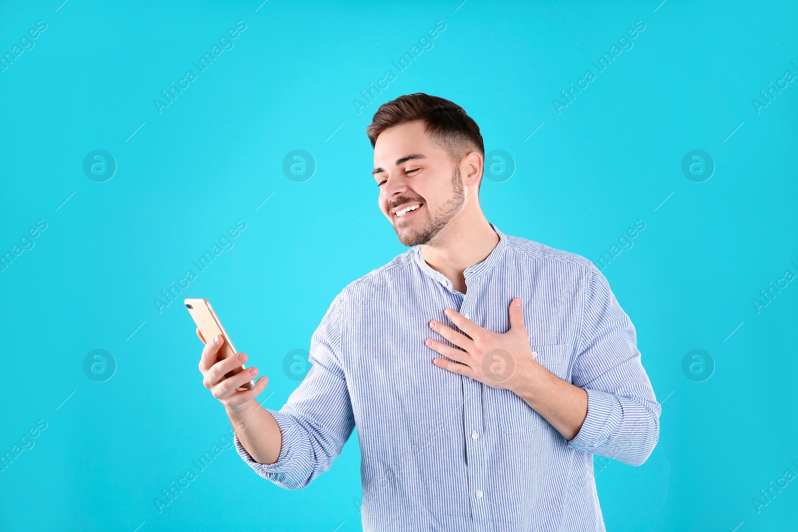 Photo of Man using mobile phone for video chat on color background