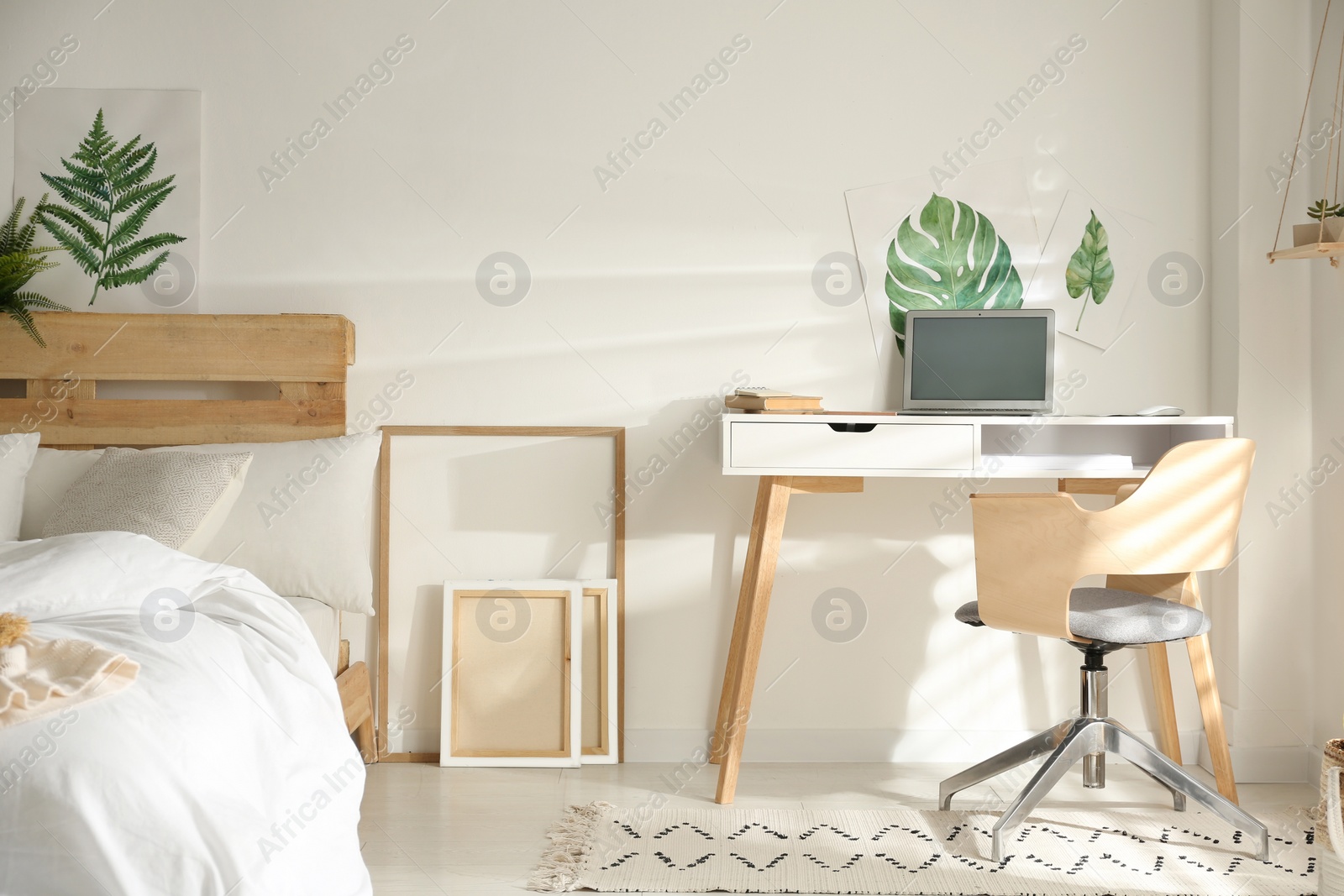 Photo of Stylish room interior with workplace and bed