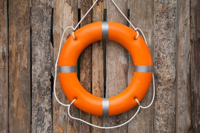 Orange life buoy hanging on wooden wall