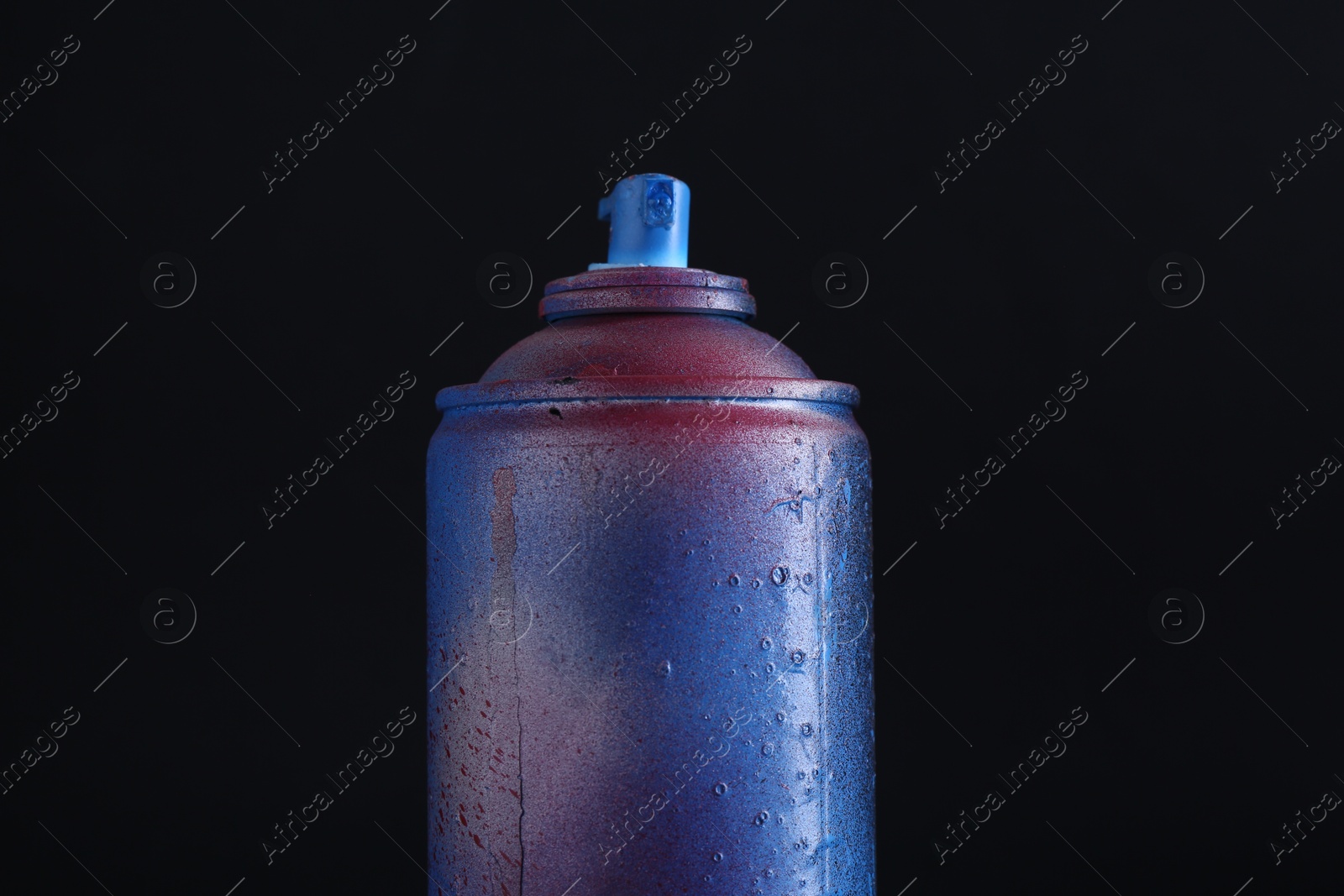 Photo of One spray paint can on dark background, closeup