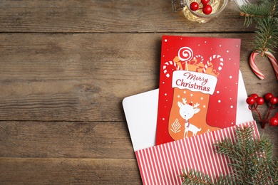 Photo of Flat lay composition with Christmas card on wooden background, space for text