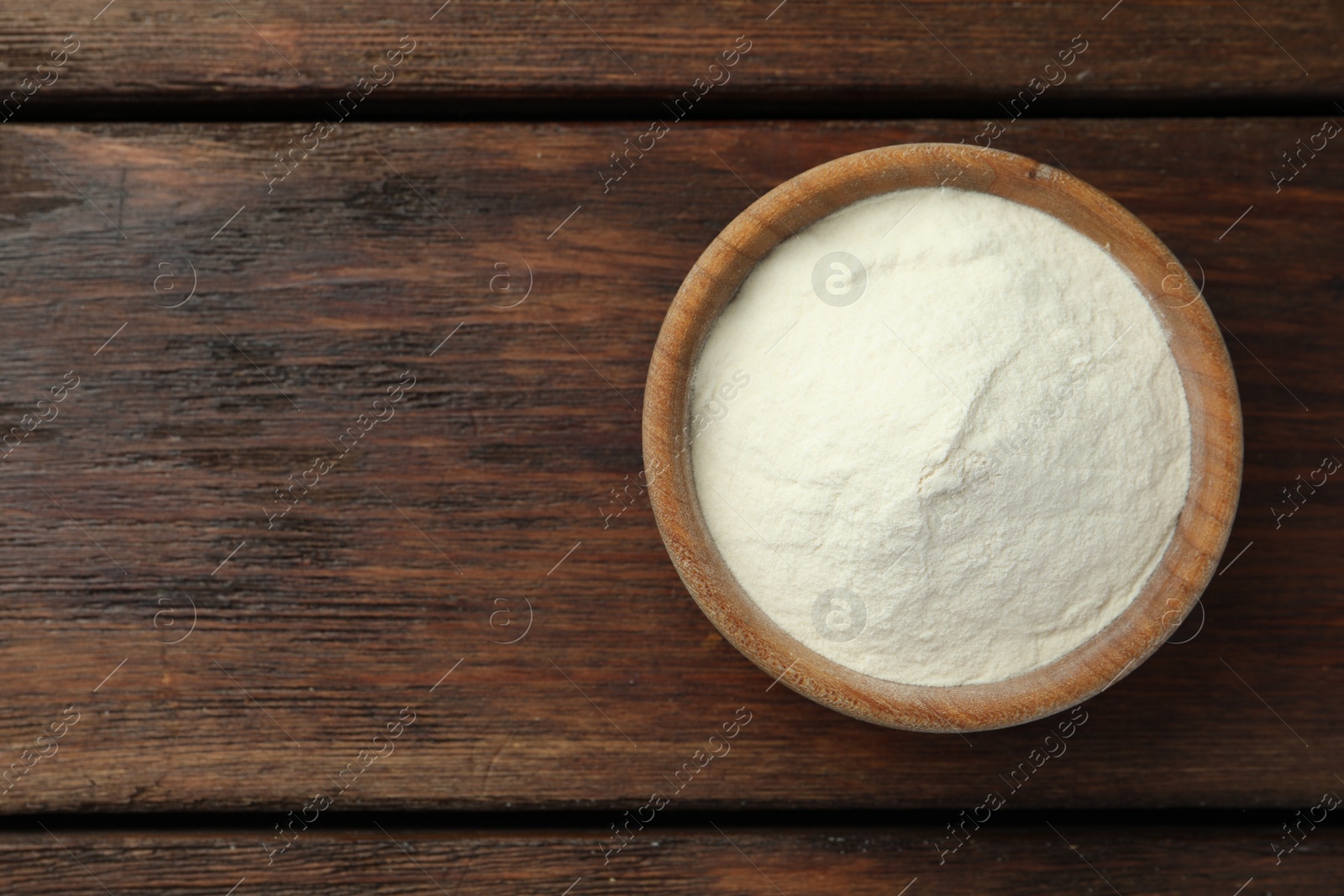 Photo of Bowl of agar-agar powder on wooden table, top view. Space for text