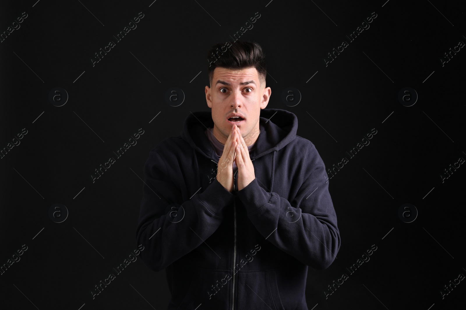 Photo of Portrait of emotional man on black background. Personality concept