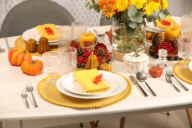 Autumn table setting with floral decor and pumpkins indoors