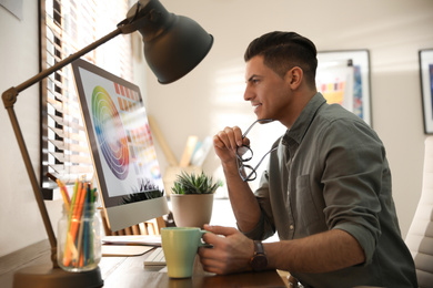 Photo of Professional designer working with computer in office