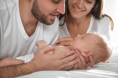 Happy couple with their newborn baby at home, closeup