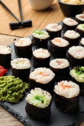 Photo of Tasty sushi rolls served on wooden table