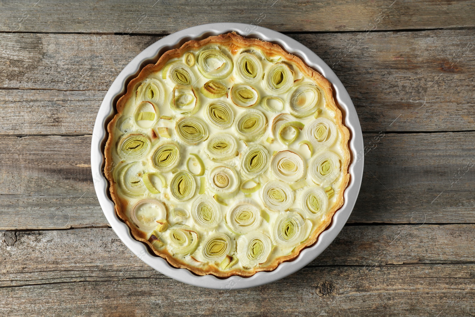 Photo of Tasty leek pie on old wooden table, top view