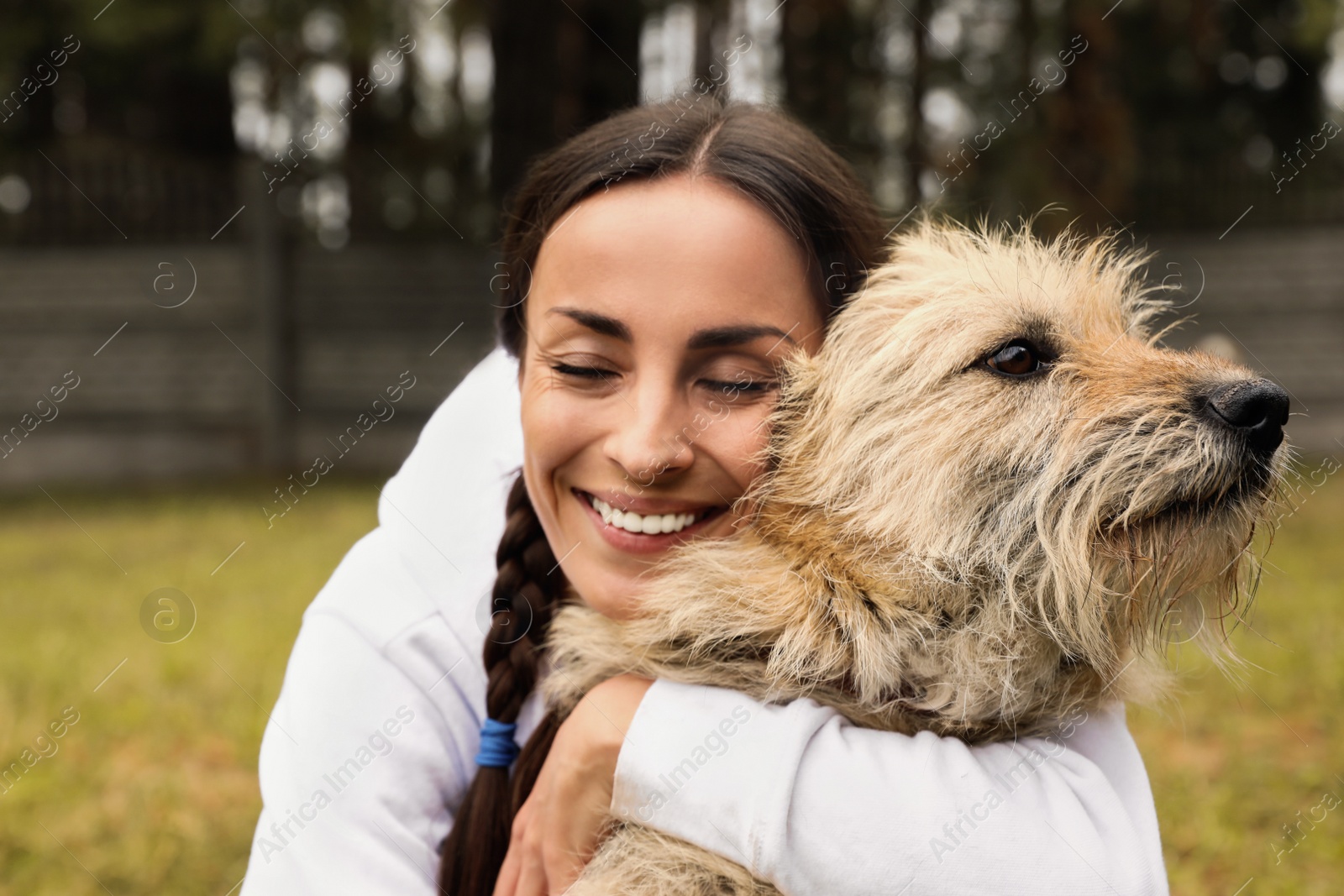 Photo of Female volunteer with homeless dog at animal shelter outdoors