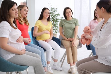 Group of pregnant women with midwife at courses for expectant mothers indoors
