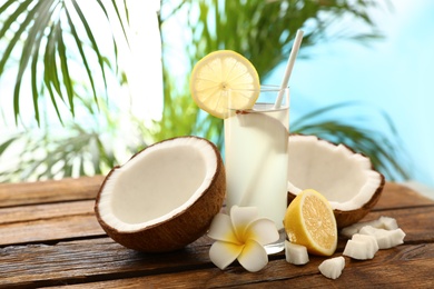 Composition with glass of coconut water and lemon on wooden table