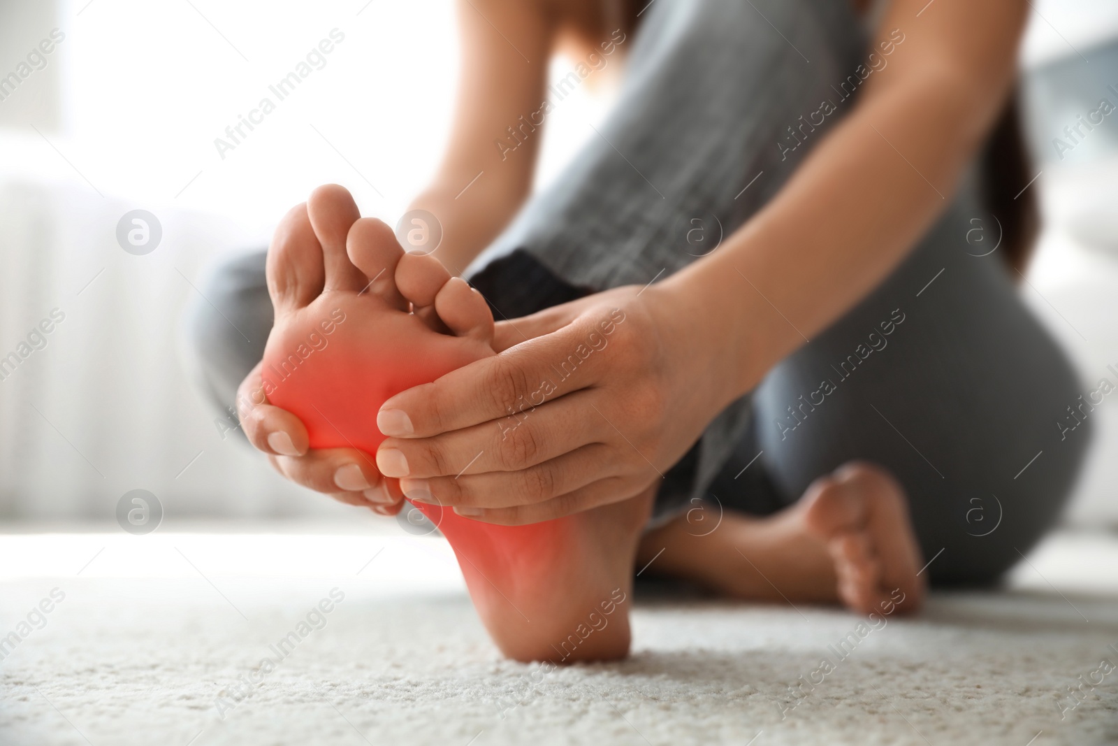 Image of Woman suffering from foot pain at home, closeup