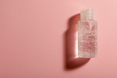 Photo of Bottle of cosmetic gel on pink background, top view. Space for text