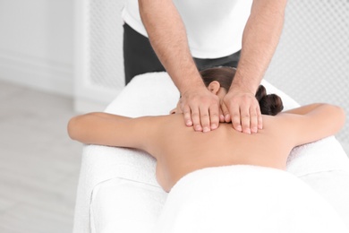 Relaxed woman receiving back massage in wellness center