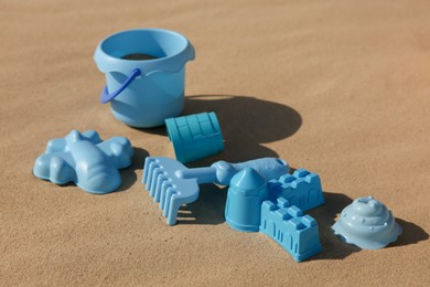 Photo of Set of plastic beach toys on sand. Outdoor play