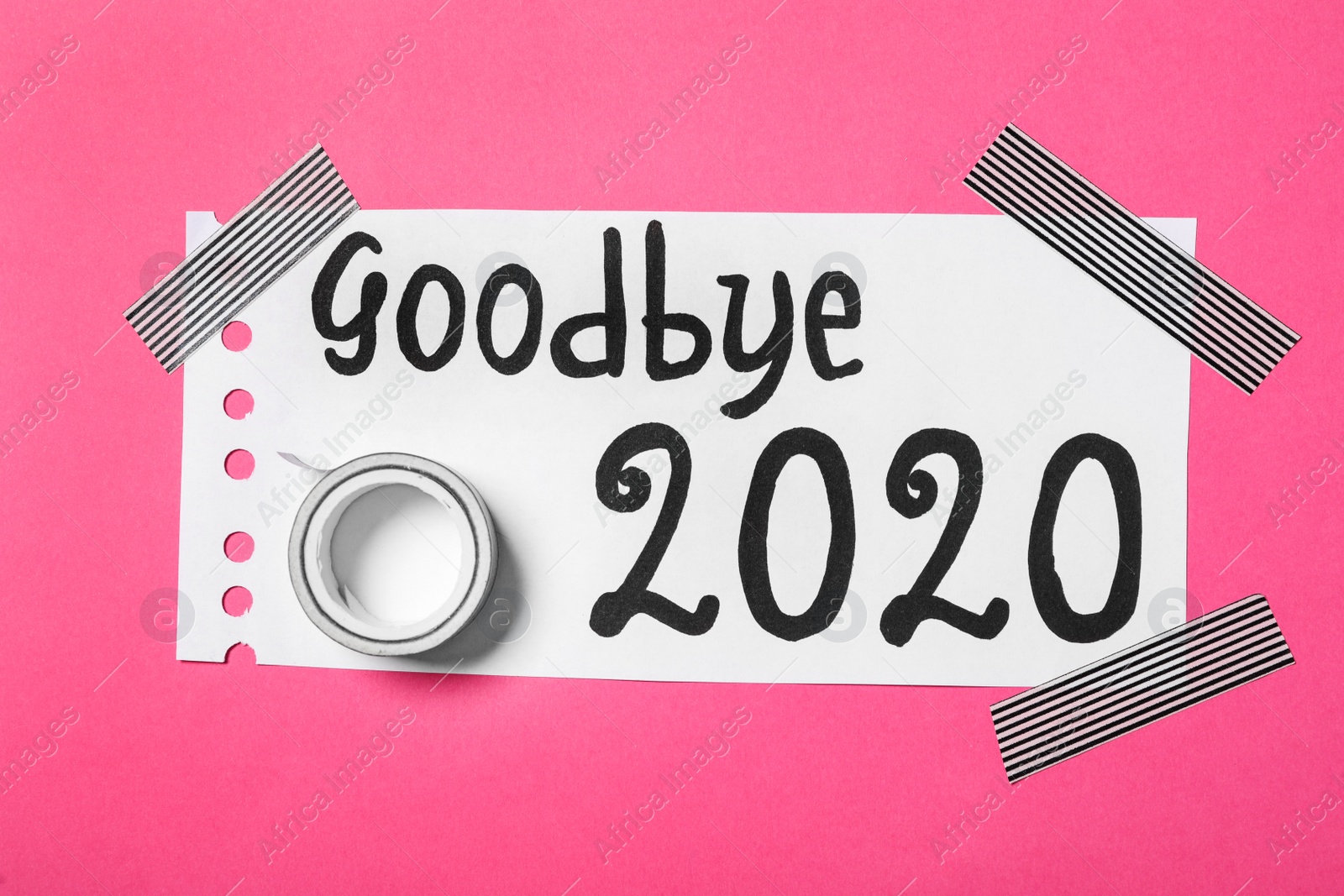 Photo of Paper with text Goodbye 2020 and adhesive tape on pink background, top view