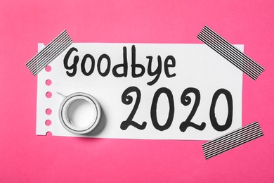 Photo of Paper with text Goodbye 2020 and adhesive tape on pink background, top view