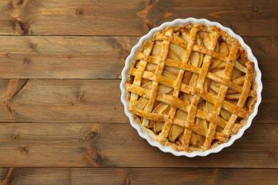 Photo of Tasty homemade quince pie on wooden table, top view. Space for text