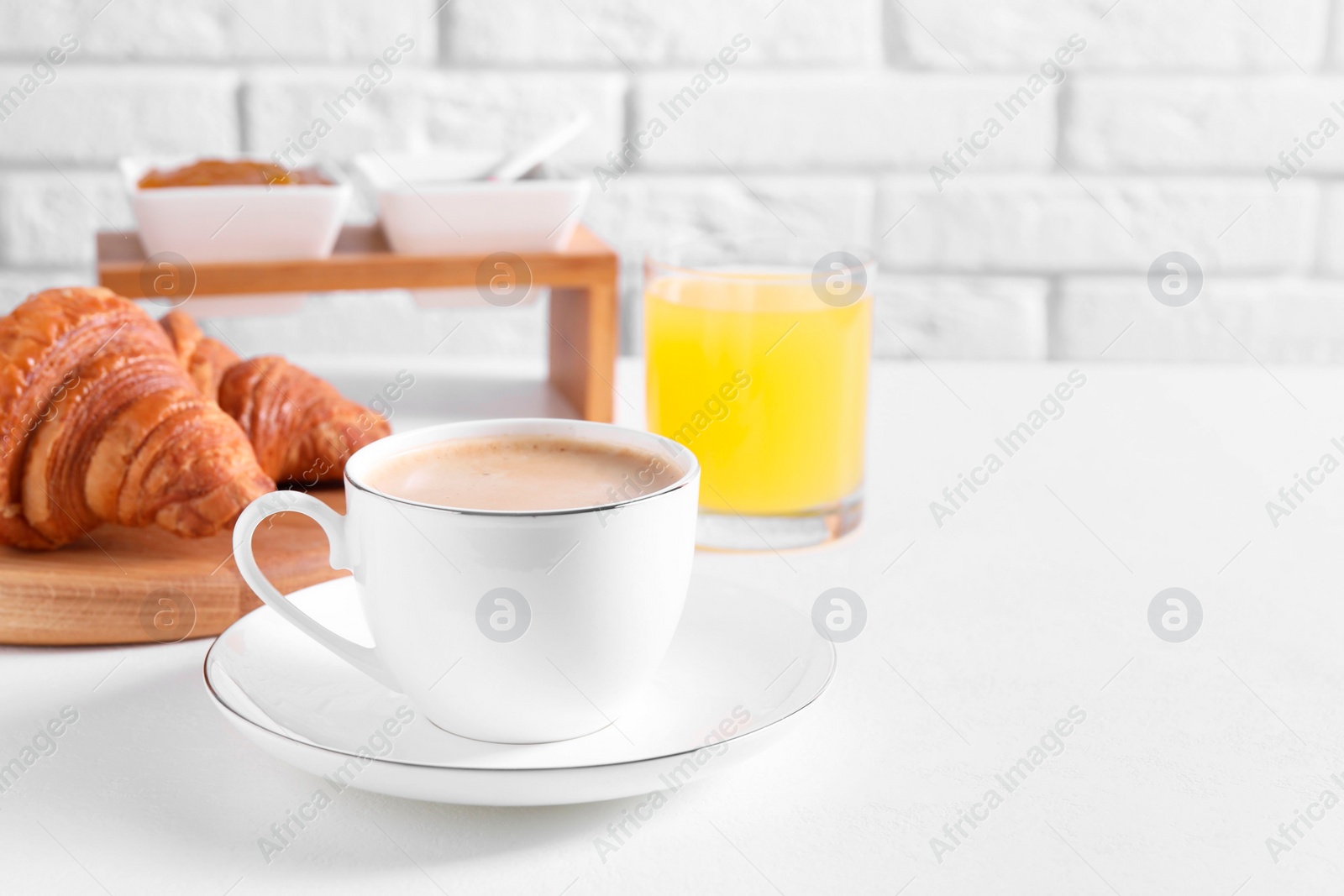 Photo of Breakfast time. Fresh croissants and coffee on white table. Space for text