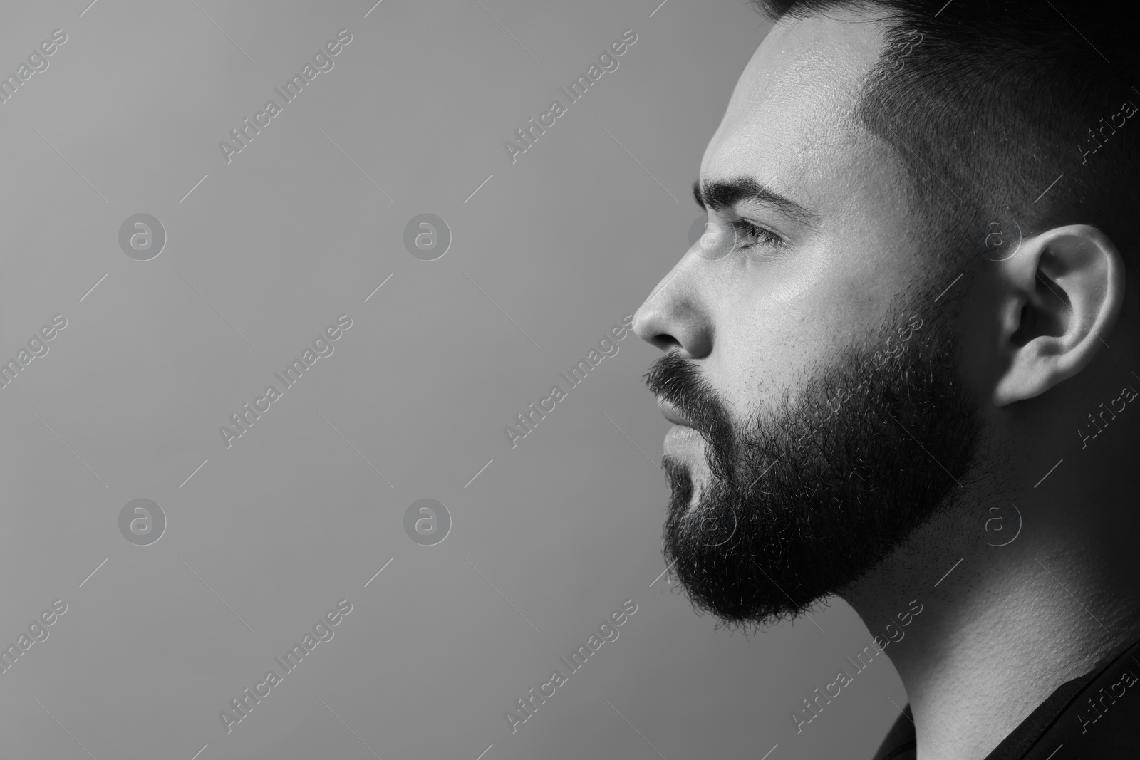 Photo of Portrait of handsome bearded man on grey background, space for text. Black and white effect