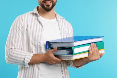 Photo of Man with folders on light blue background, closeup